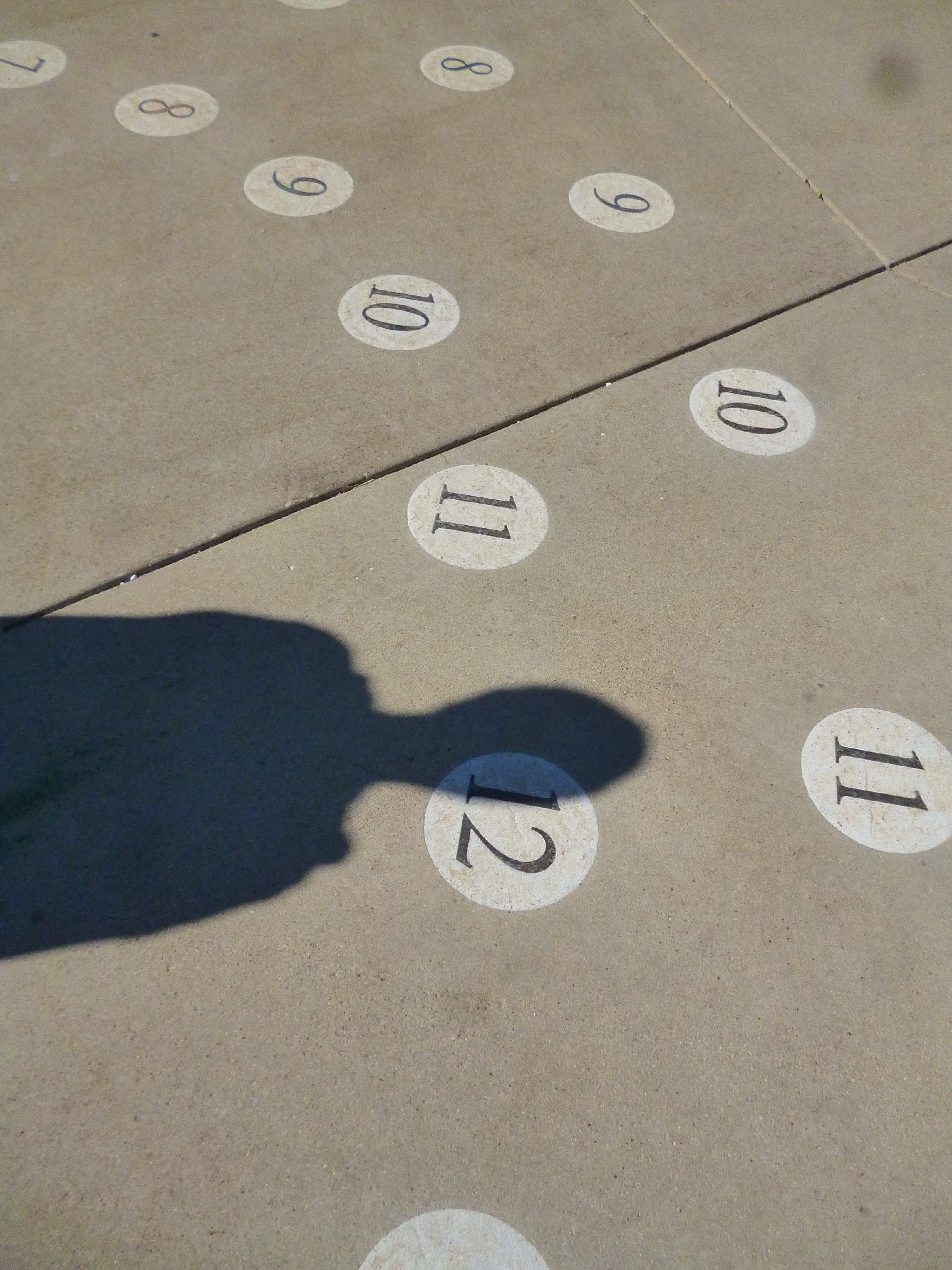 David's shadow on the ground next to a number 12.