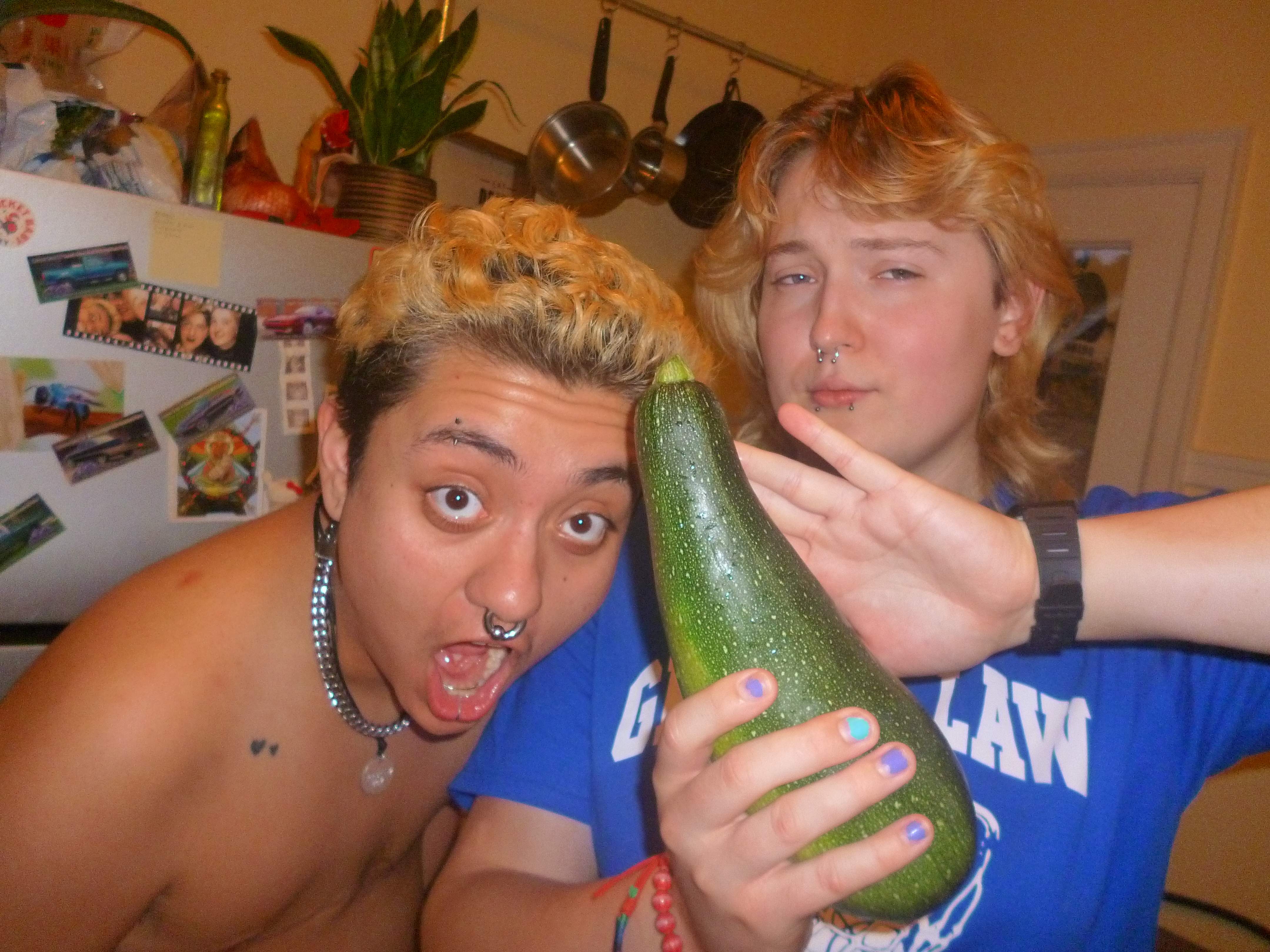David with his mouth agape, in awe at the size of the zucchini. Katie is holding the zucchini.