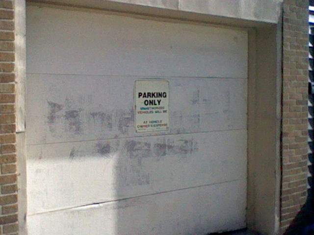 A sunfaded sign, reading: (blank) parking only, unauthorized vehicles will be (blank) at owners expense.