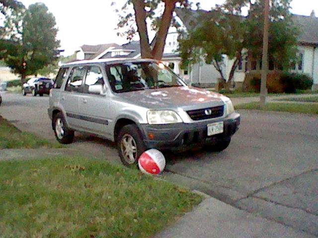 plastic beach ball against the tire of Badger's car.